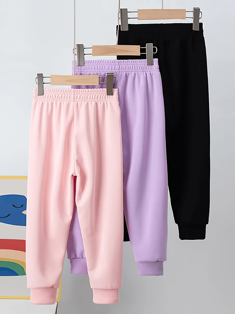 Kids Sport Jogger Sweatpants with Elastic Waist - SF3888 in pink, purple, and black hanging on a rack.