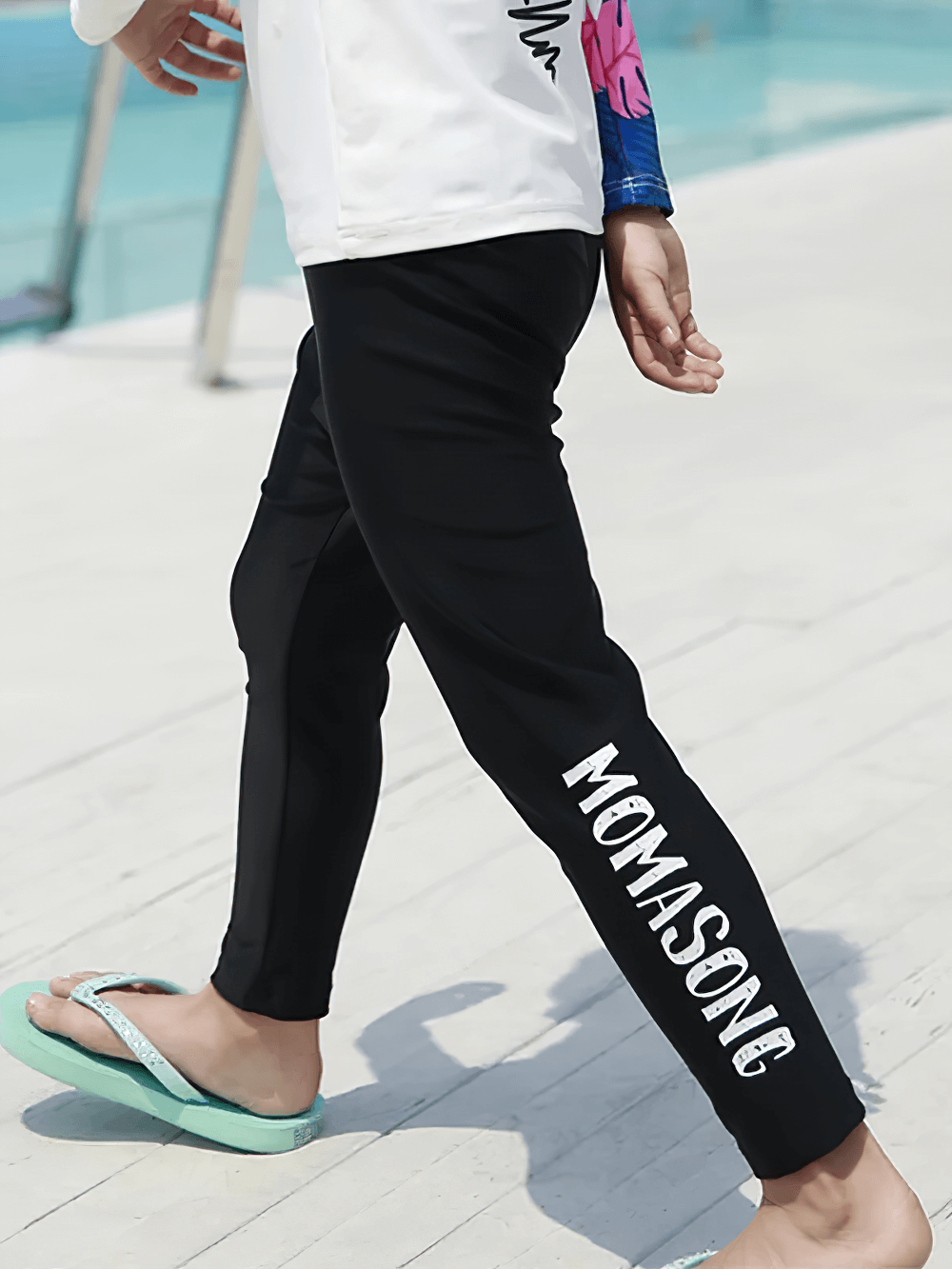 Child wearing Kid's Sport Long Pants with Quick Dry Fabric - SF3586 by the poolside, highlighting the elastic waist and sun-protection.