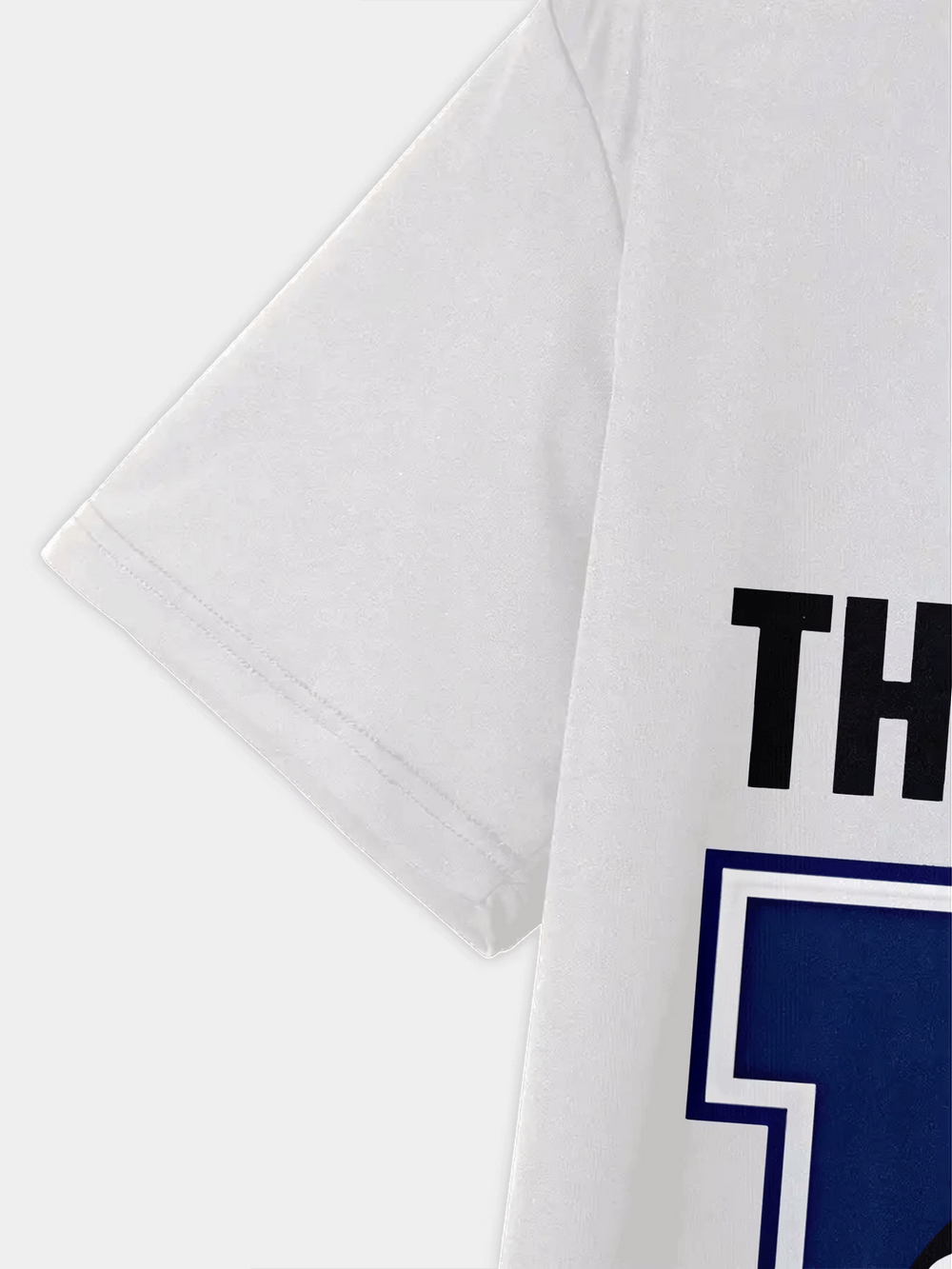 Close-up view of a white kids' T-shirt featuring partial text and bold blue lettering, perfect for young football fans. Product code SF3131.