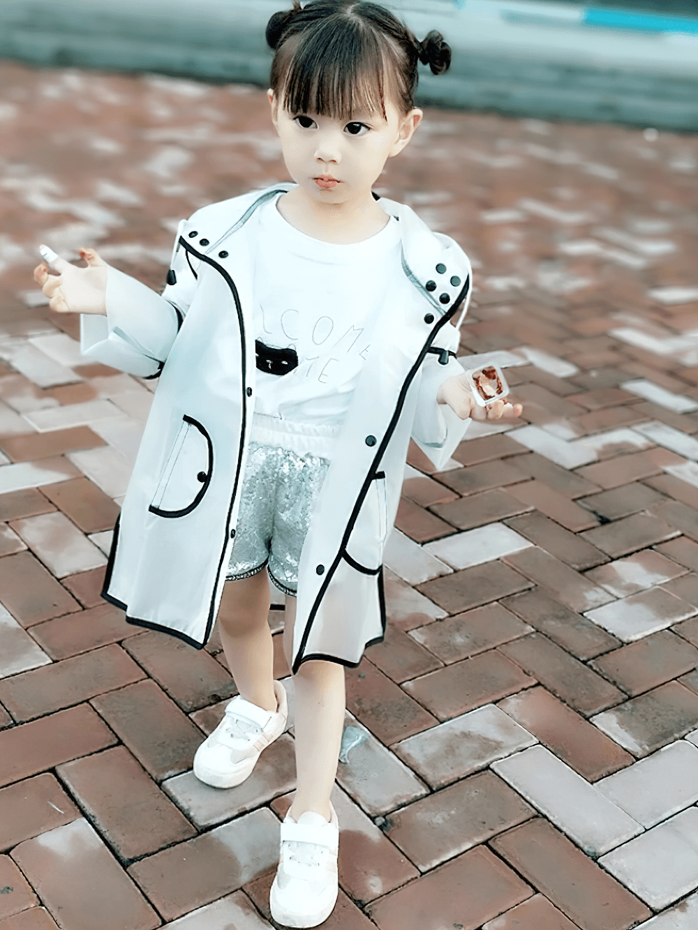 Child wearing Kids Transparent Long Hooded Raincoat - SF3671 with striped sleeves and playful black trim, perfect for rainy playtime.