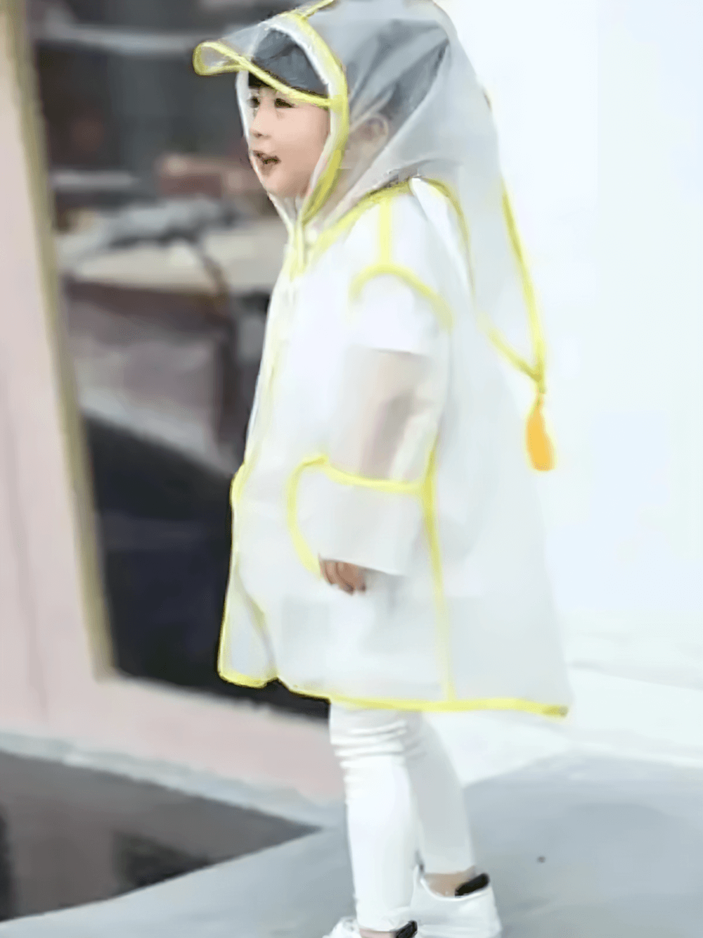 Kid wearing Kids Transparent Long Hooded Raincoat - SF3671 with yellow trim, enjoying a rainy day with cozy hood and visor.
