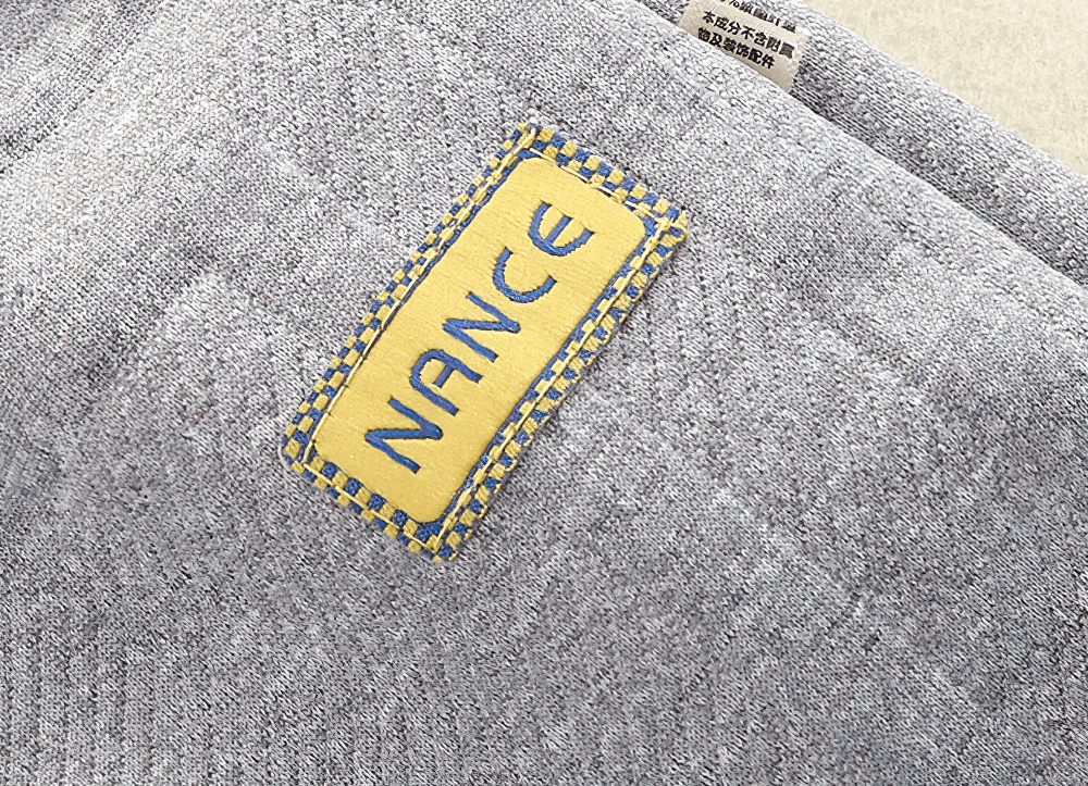 Close-up of a gray Kids Warm Sport Jogger Pants with Elastic Waist - SF3884 showcasing a yellow and blue stitched label.