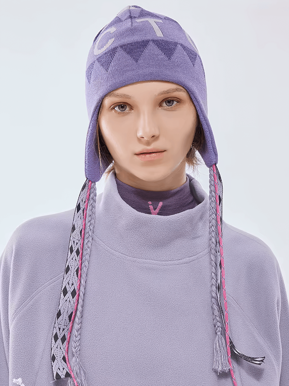 Boho knit ski hat with ear flaps on model, featuring stylish print in soft cotton, ideal for autumn and winter outdoor adventures.