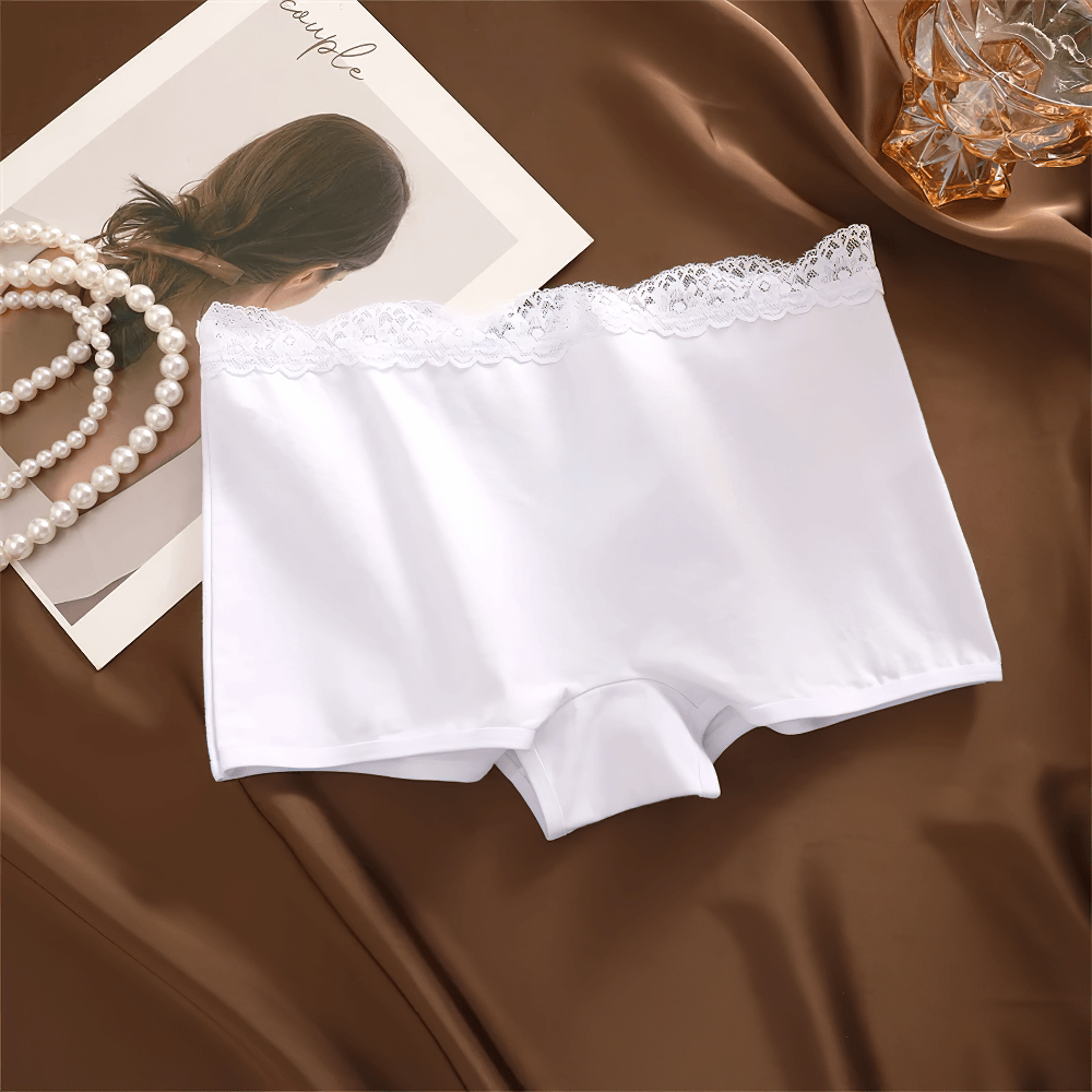 White lace-trimmed boyshort panties on brown satin, showcasing elegant lace waistband and soft breathable fabric for everyday wear.