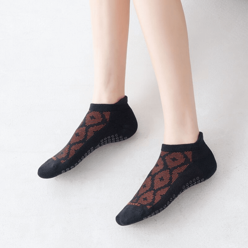 Ladies black breathable anti-slip cotton Pilates socks on feet, showcasing stylish design and comfort for workouts or casual wear.