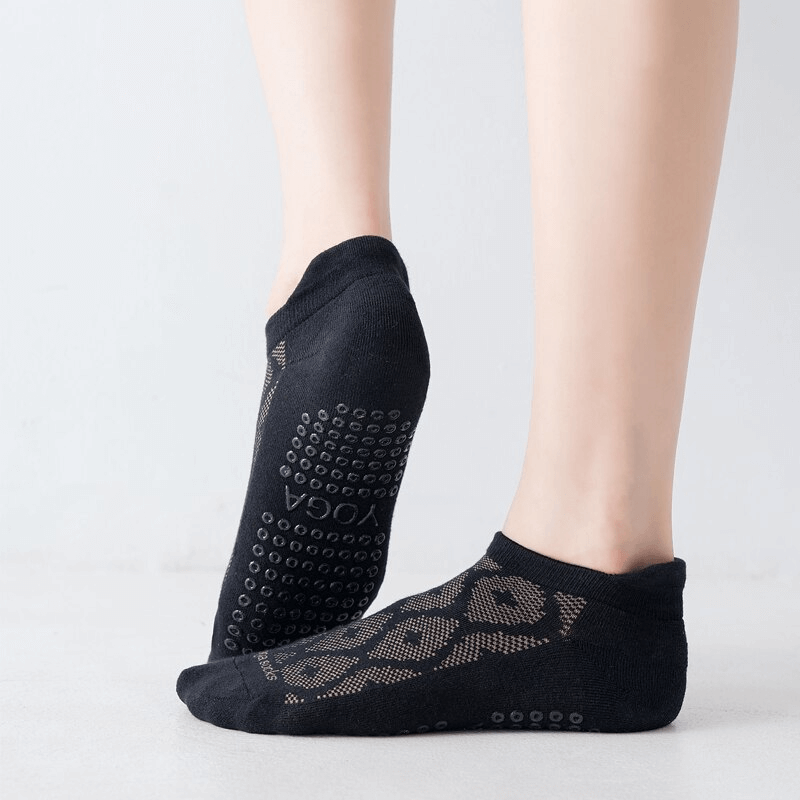 Black breathable anti-slip cotton Pilates socks for women, providing comfort and support, shown on feet against a light background.