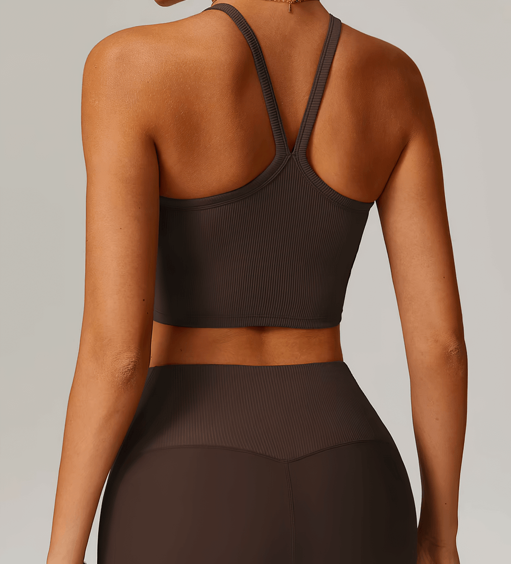 Back view of a woman wearing a ribbed racerback sports tank top in dark color, perfect for yoga and running, offering support and flexibility.