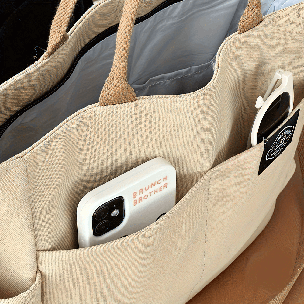 Interior view of large canvas tote bag SF2663 showcasing multi-pocket design with phone and sunglasses inside.