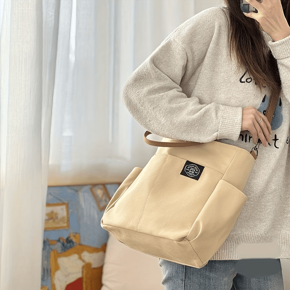 Versatile large canvas tote bag with multi-pocket design in beige, worn crossbody for stylish and functional daily use. SF2663