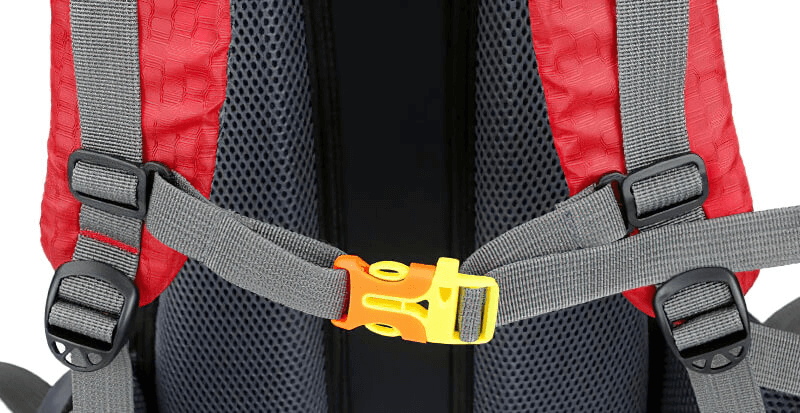 Close-up of adjustable shoulder straps on a red travel backpack with a yellow buckle.
