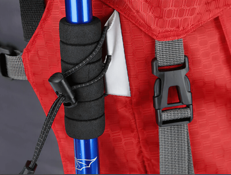 Close-up of red large travel backpack with rain cover showcasing buckle and pole attachment