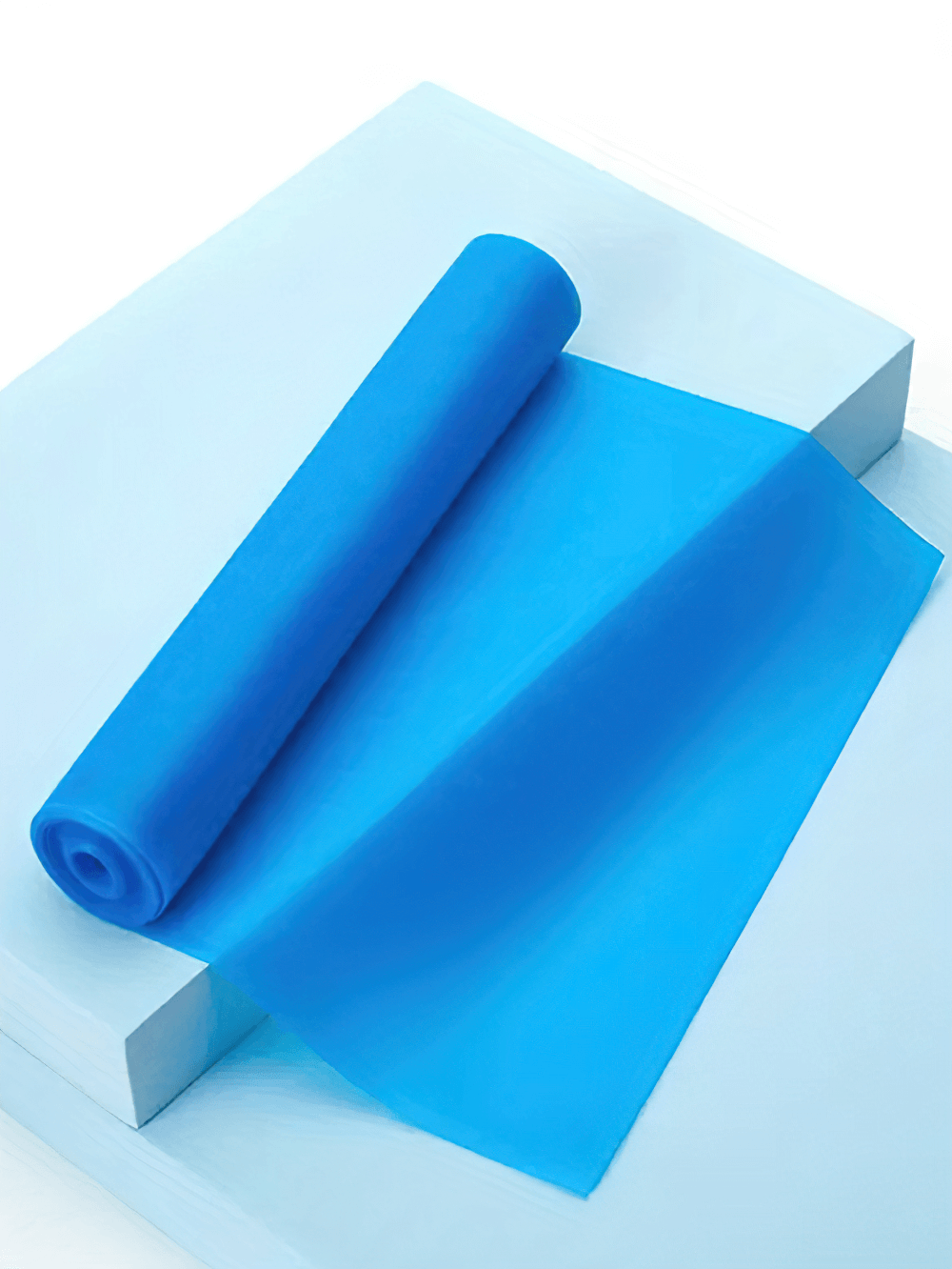 Blue latex resistance band for yoga and Pilates workouts, rolled on a white surface, ideal for home exercises and physical therapy.