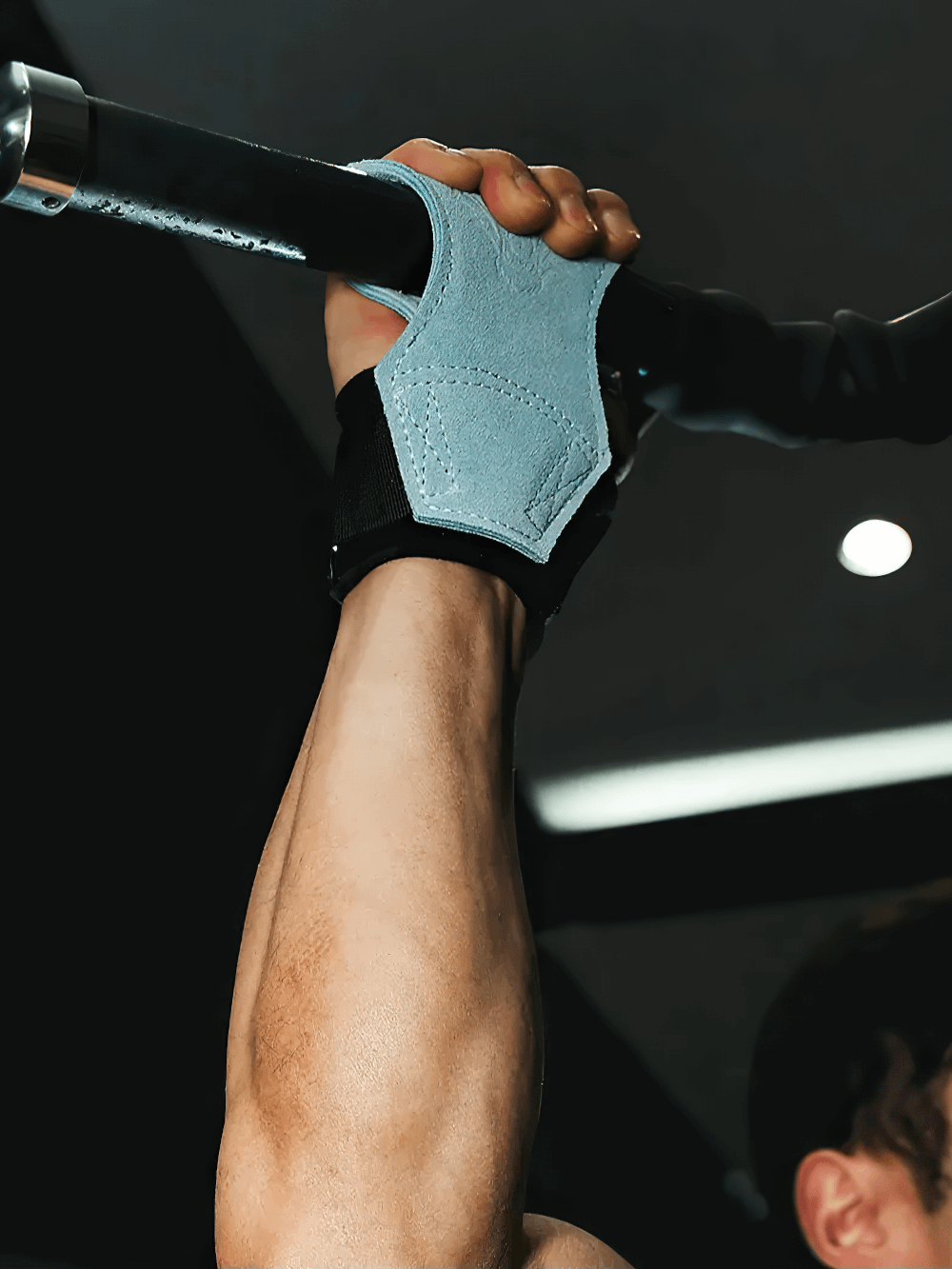 Hand using Leather Gym Hand Grips with Wrist Support Straps - SF3519 on pull-up bar for enhanced performance and protection.