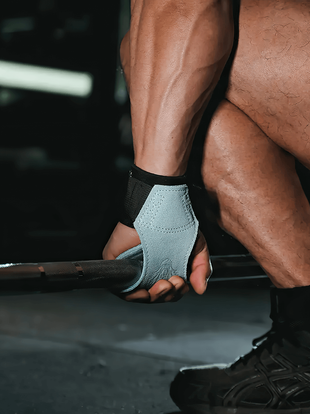 Athlete lifting weights with Leather Gym Hand Grips with Wrist Support Straps - SF3519, featuring durable suede for grip and support.