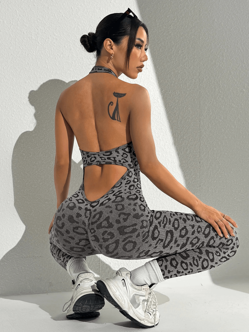 Model wearing Leopard Print Yoga Jumpsuit with Open Back Design - SF4232, showcasing the bold pattern and athletic style.