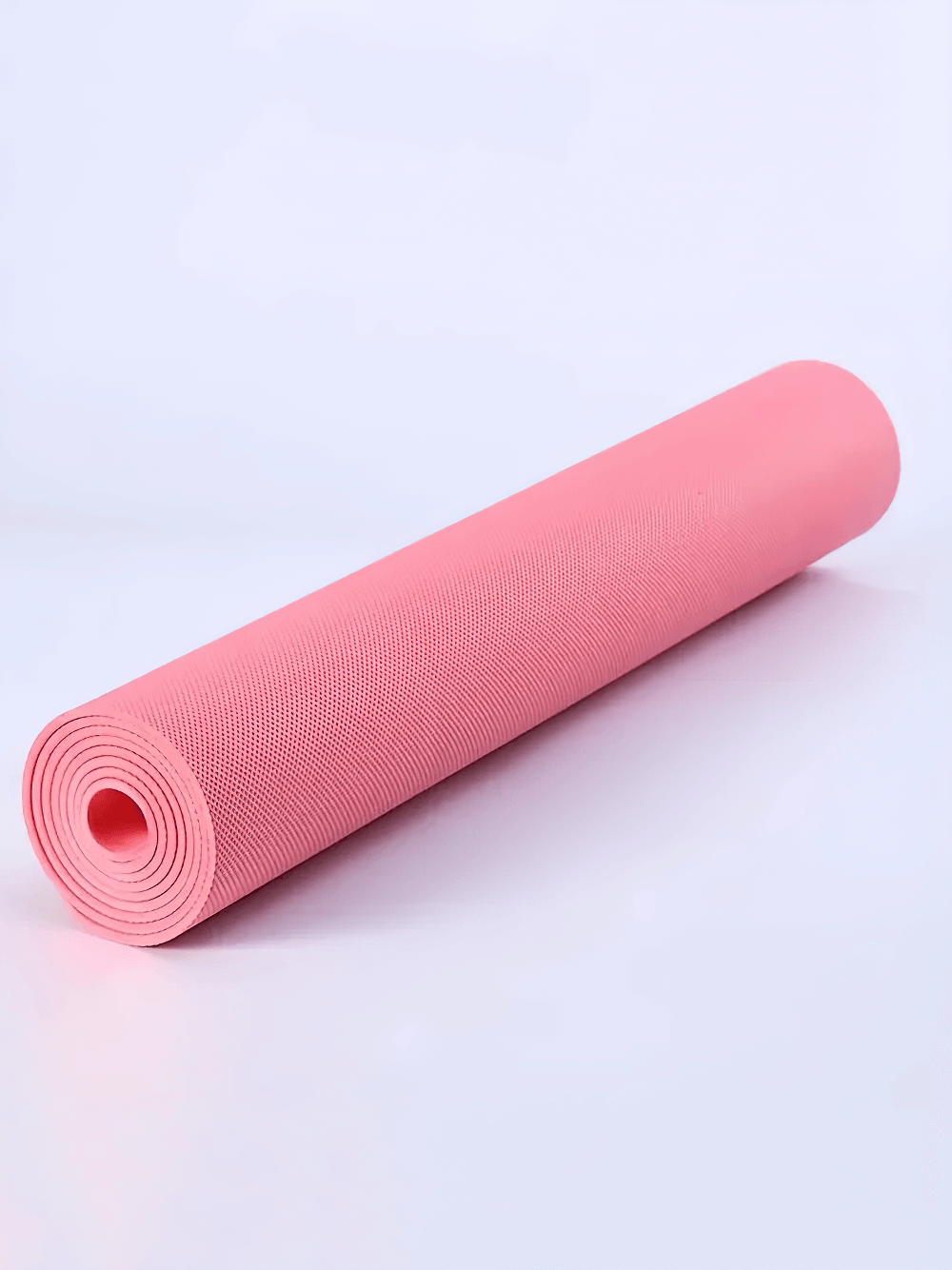 Rolled pink lightweight anti-slip EVA yoga mat for training and fitness, showcasing durability and easy portability.
