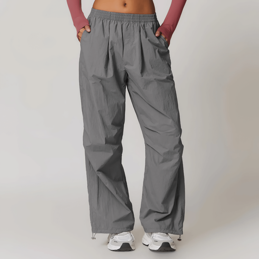 Woman wearing lightweight high-waist gray pants with pockets, perfect for yoga, running or hiking. Stylish and breathable design.