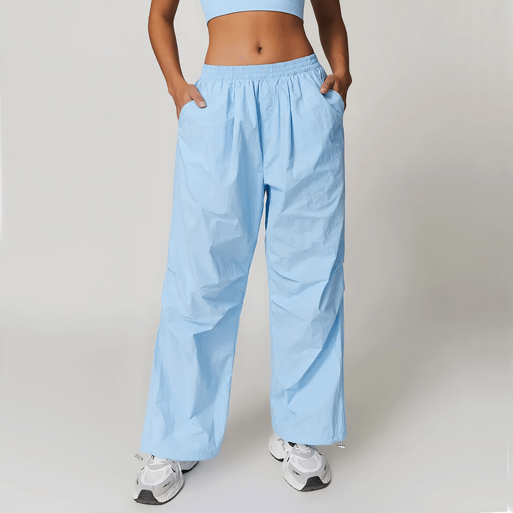 Woman wearing light blue high-waist breathable nylon yoga pants with pockets, perfect for fitness and outdoor activities.