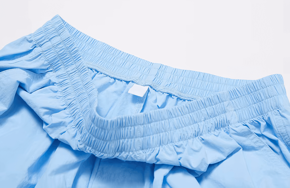 Close-up of light blue high-waist women's pants with an elastic waistband, highlighting breathable fabric and stylish design for active wear.