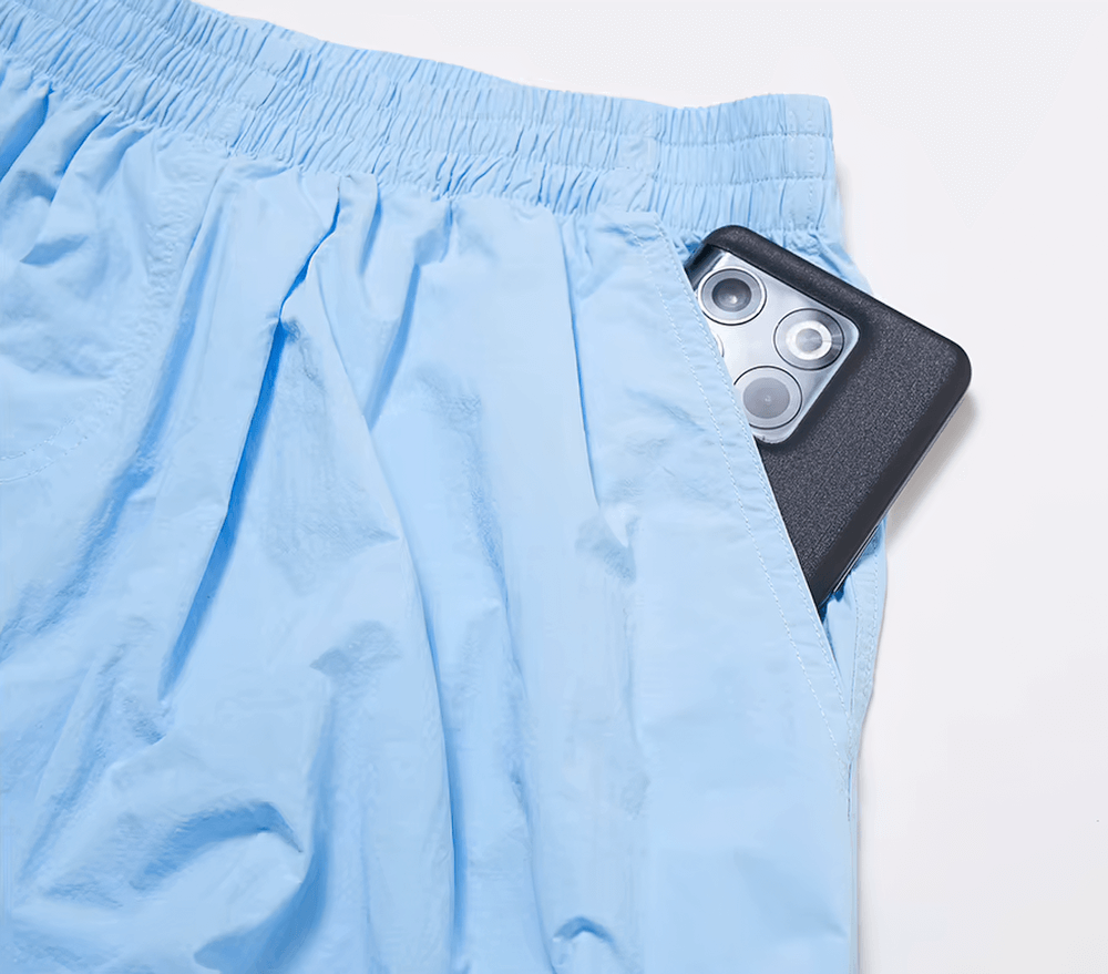 Lightweight blue women's pants with elastic waist, featuring a smartphone snugly placed in the functional side pocket.