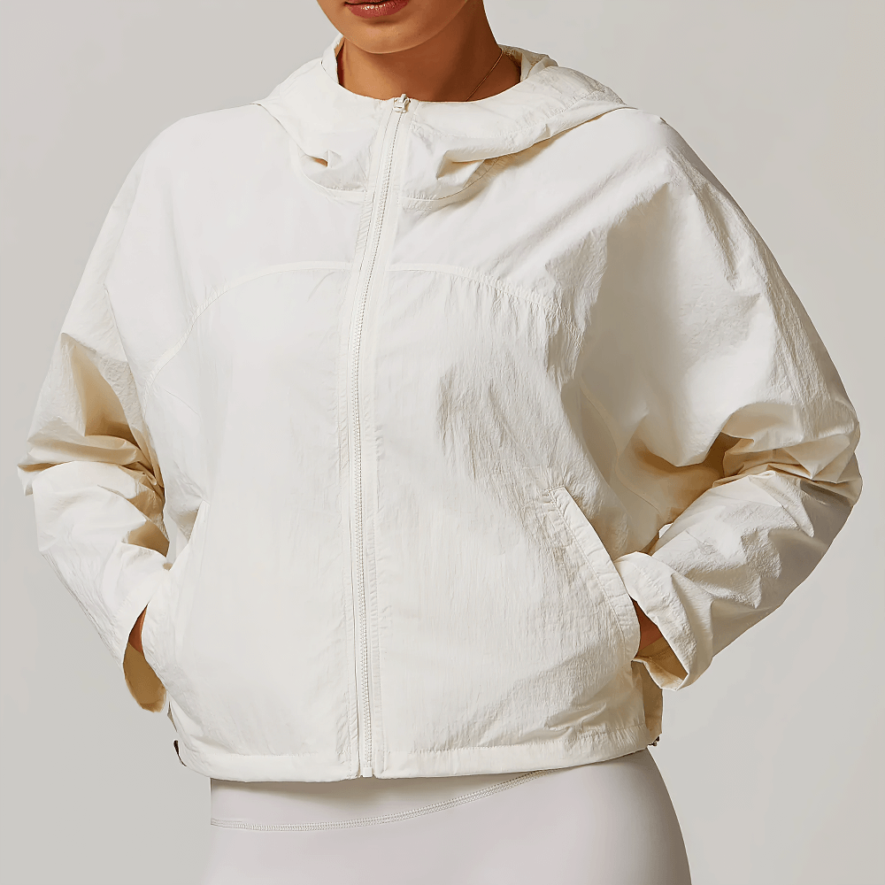 Lightweight white hooded jacket with zip front and relaxed fit, perfect for active women