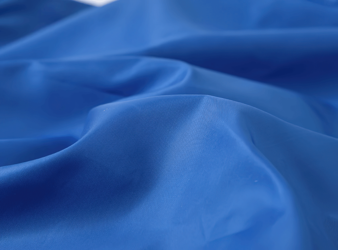 Vibrant blue fabric texture of Lightweight Hooded Windbreaker with Rainbow Zipper - SF3635 showcasing its smooth and stylish design.