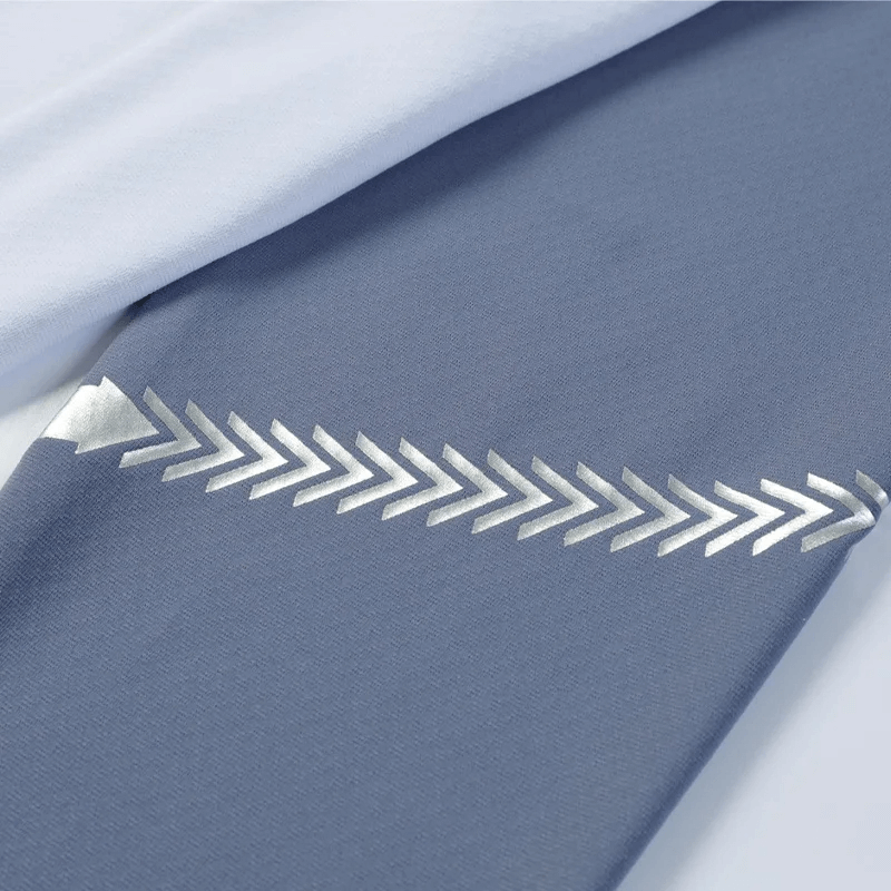 Close-up of the Lightweight Long-Sleeved Zip Shirt with sleek silver chevron design on blue fabric, showcasing stylish athletic wear details.