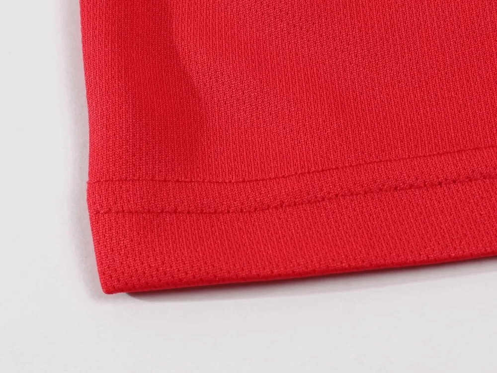 Close-up of red polyester fabric showcasing the breathable material of the Lightweight Men's Athletic T-Shirt for running and workouts.