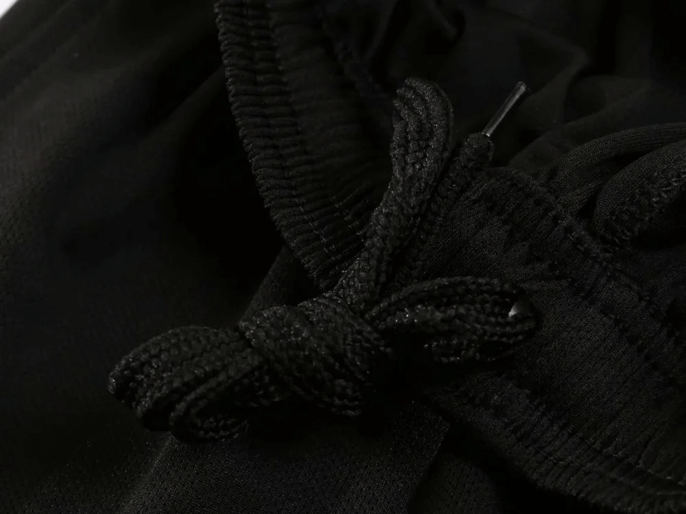 Close-up of drawstring detailing on men's athletic black shorts from the lightweight SF2025 set, showcasing fabric texture and craftsmanship.