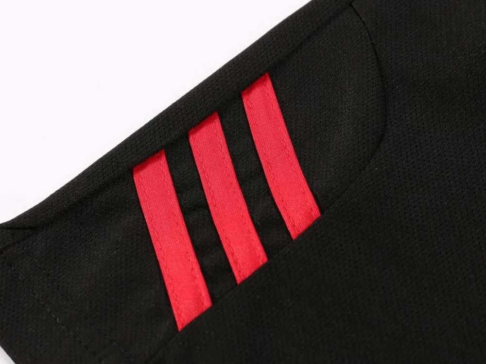 Close-up of black athletic shorts with red stripe detail on the pocket.