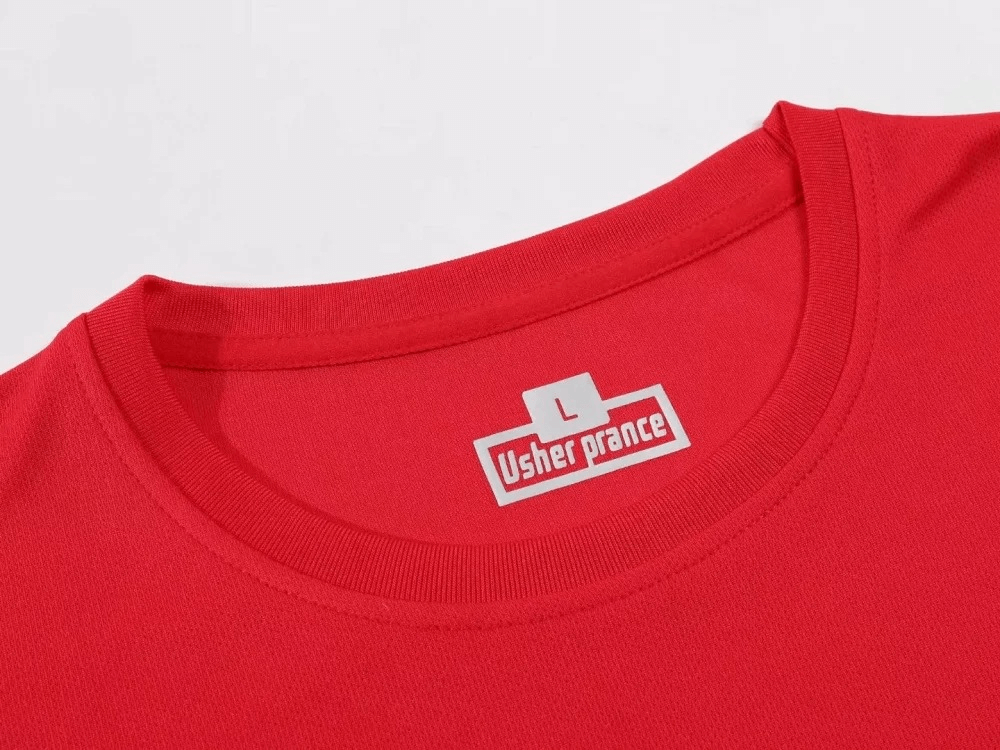 Close-up of a red men's athletic T-shirt with an O-neck collar, featuring a white label and sporty design.