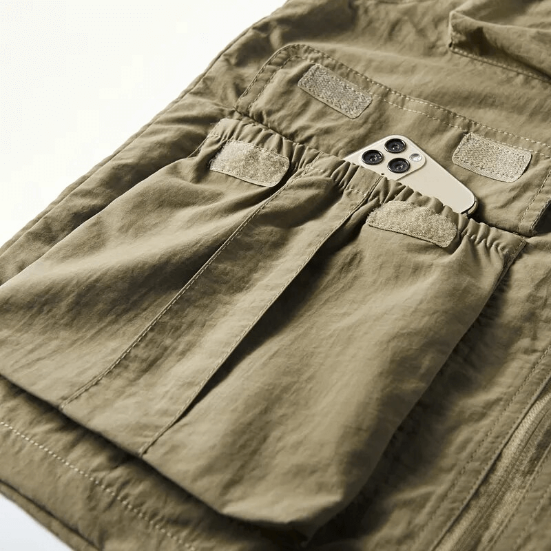 Close-up of lightweight men's vest showing pocket detail with phone inside, showcasing practical outdoor design.