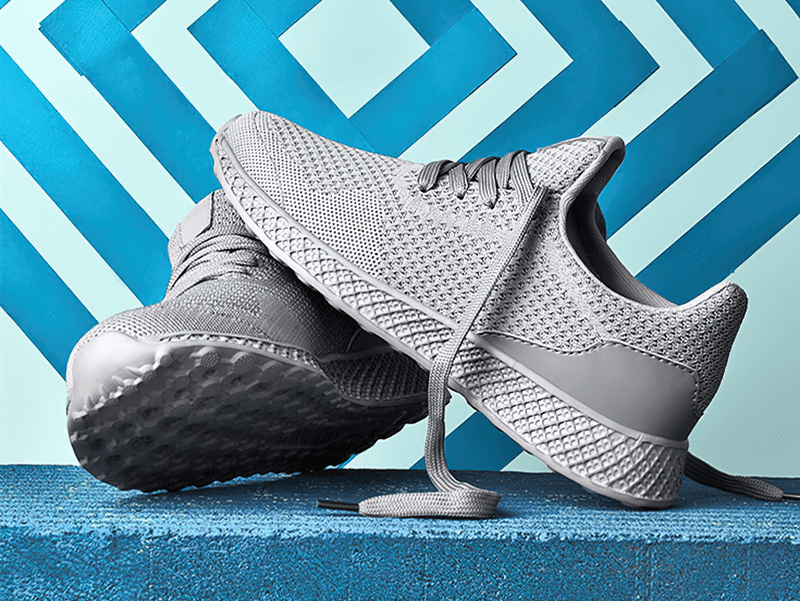 Gray Lightweight Mesh Tennis Shoes for Men's Outdoor Training with EVA insole and rubber outsole displayed on a blue geometric background