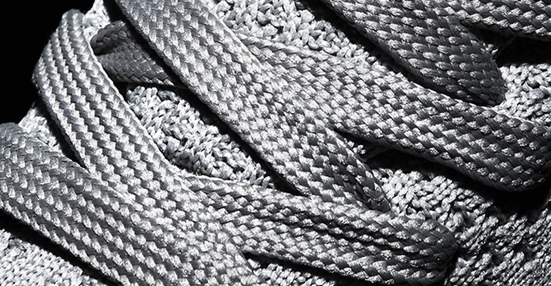 Close-up of mesh and laces on men's lightweight outdoor training shoes, showcasing durable construction and breathable materials.
