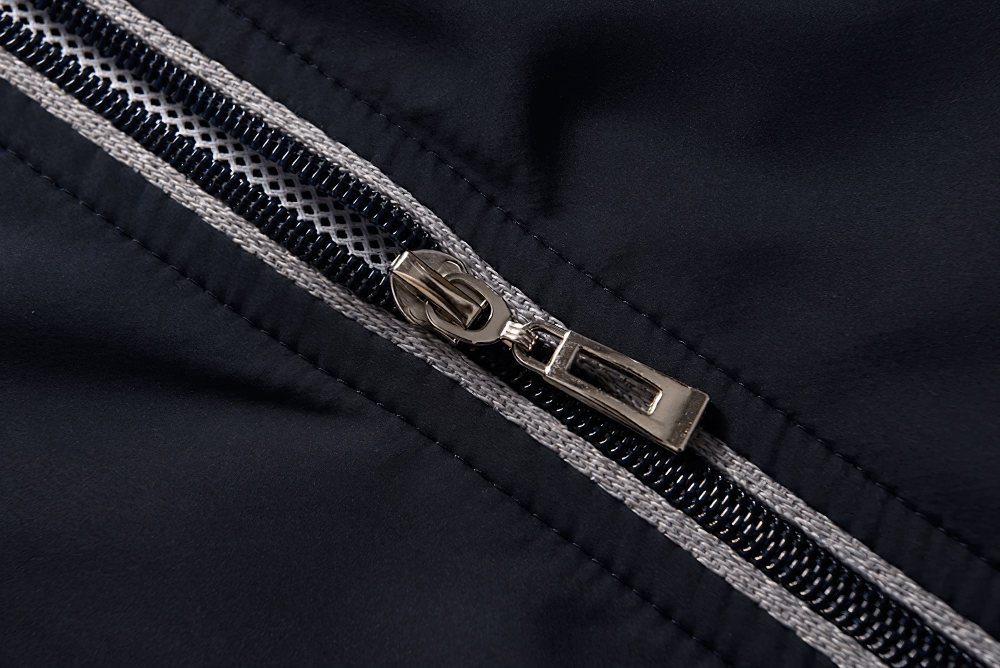 Close-up of a silver zipper on a black windproof jacket, part of the SF2284 lightweight sports tracksuit.