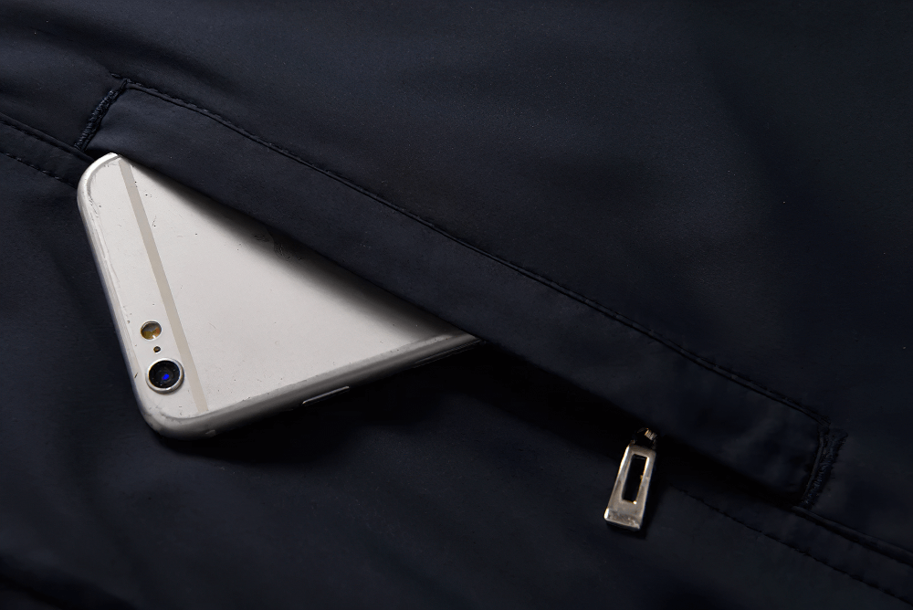 Smartphone snugly fits in the zippered pocket of the SF2284 sports jacket, demonstrating secure storage for outdoor activities.