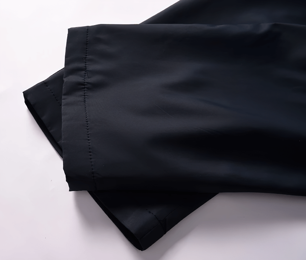 Close-up of black waterproof tracksuit pants from SF2284, showcasing breathable polyester fabric and durable stitching.