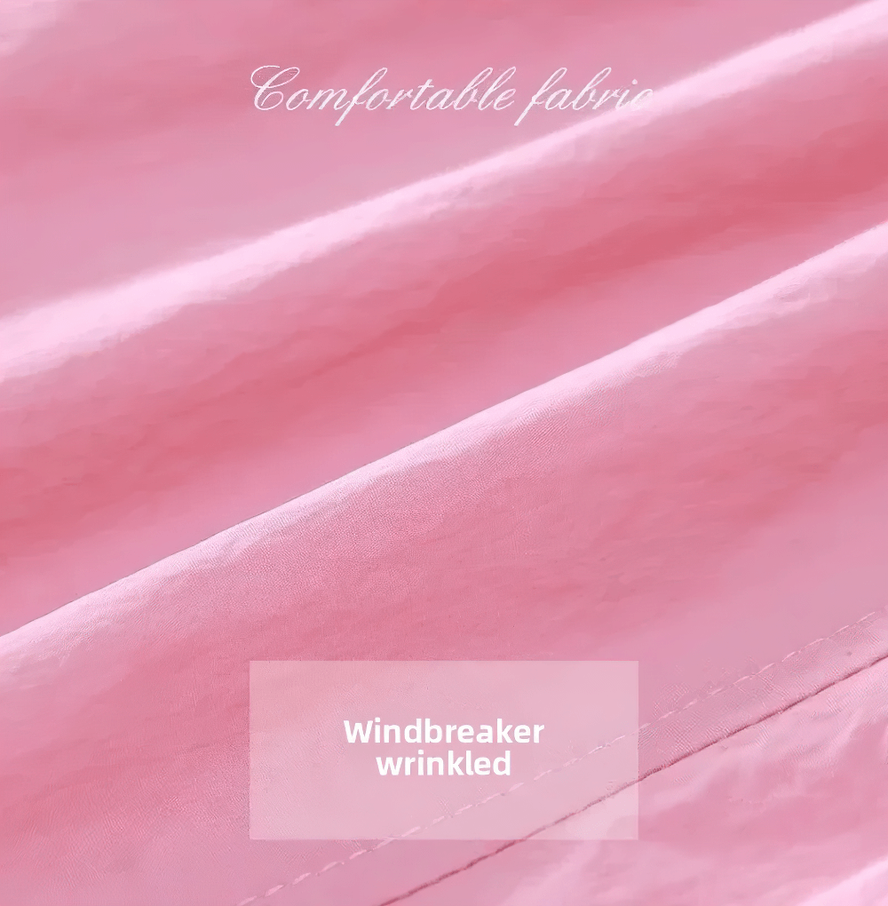Close-up of pink windbreaker fabric with wrinkles, showcasing its comfortable texture and quality.