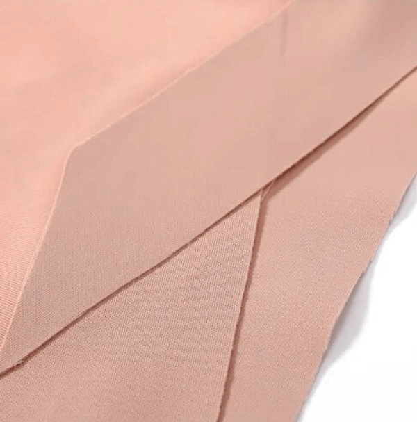 Lightweight seamless low waist panties in blush pink, showcasing breathable polyester and nylon fabric. Women's stylish underwear.