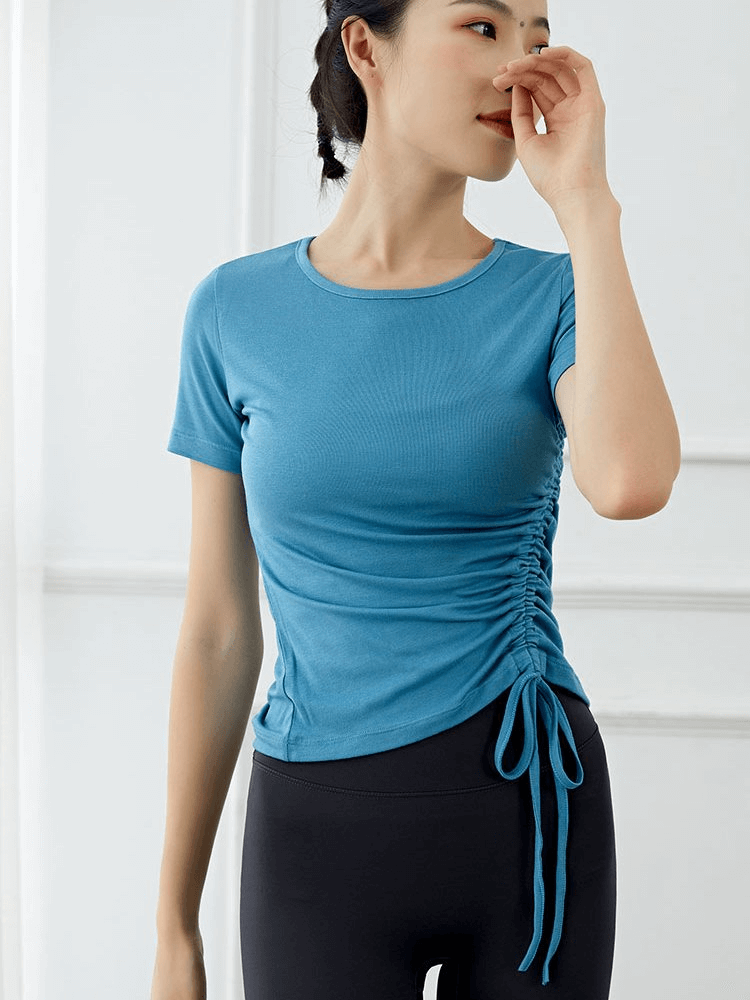 Woman in blue lightweight sporty T-shirt with side tie, perfect for yoga and summer workouts.