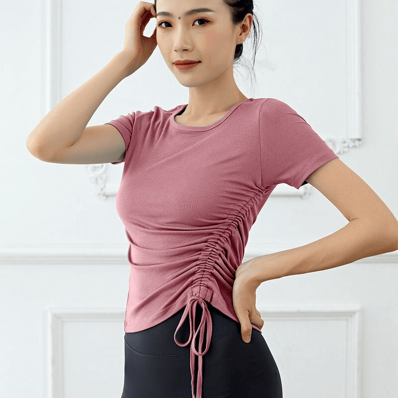 Woman wearing Lightweight Sporty Elastic T-Shirt with side tie, perfect for yoga and summer workouts. Gender: Female, Color: Pink. Product SF1273.