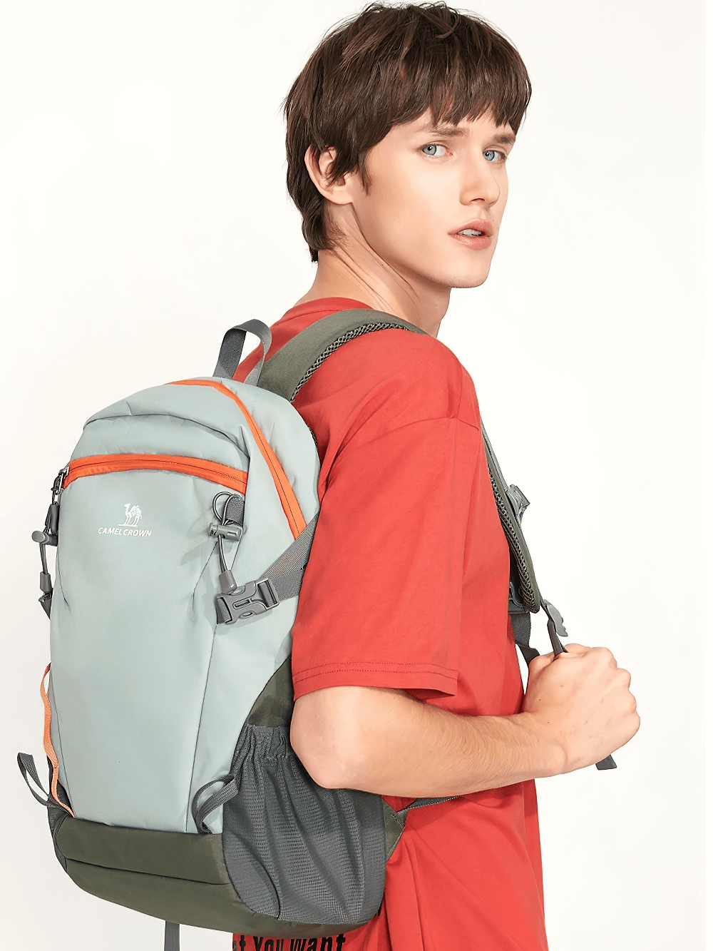 Young man wearing SF2301 lightweight waterproof hiking backpack in grey and orange, ideal for travel, hiking, and camping adventures.