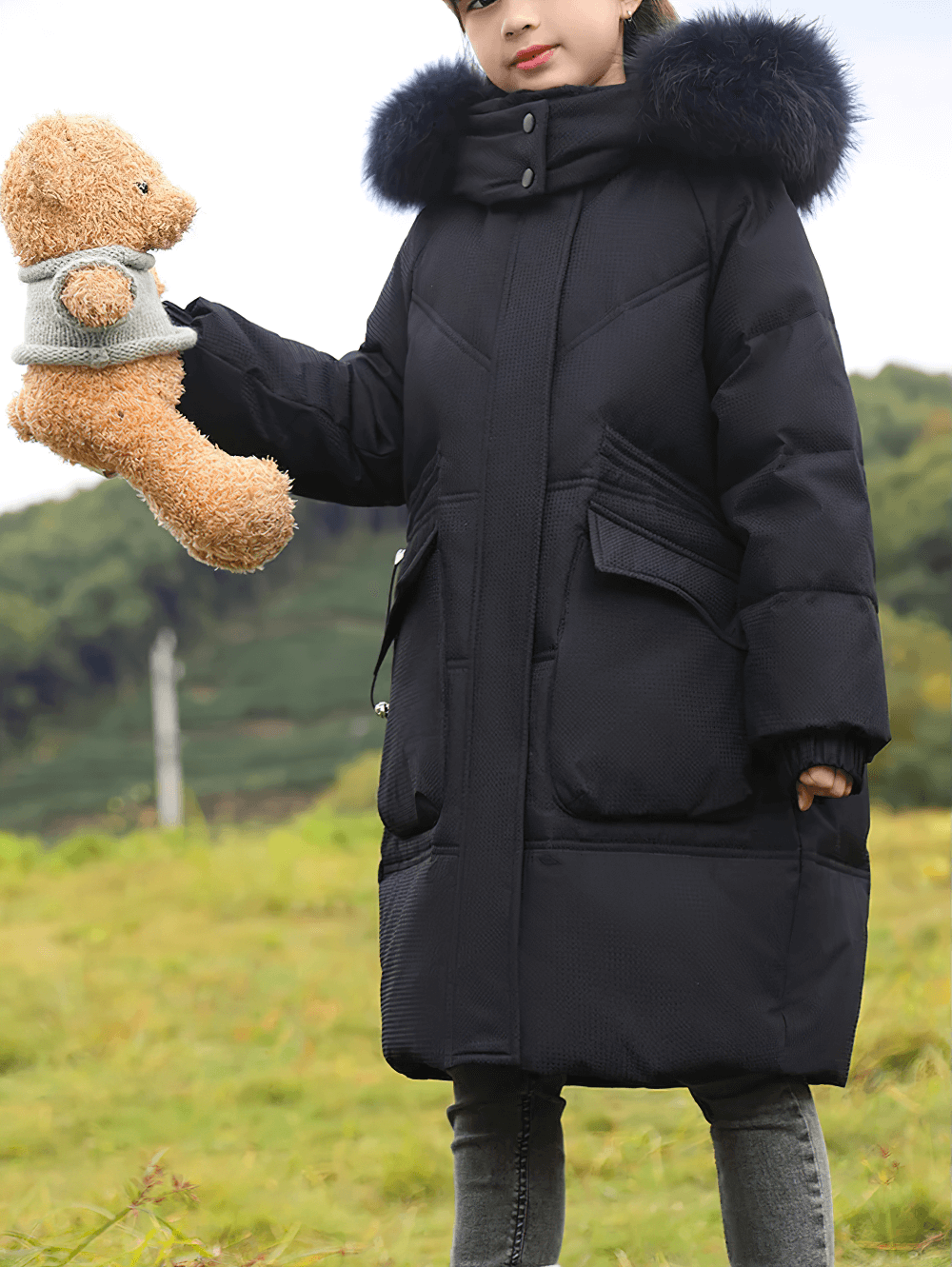 Girl wearing Long Down Coat with Hood and Faux Fur Trim - SF3525, holding teddy bear outdoors, showcasing winter style and warmth.