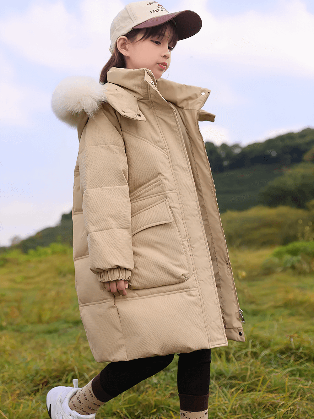 Girl wearing Long Down Coat with Hood and Faux Fur Trim - SF3525 in a beige color, featuring large pockets and a warm padded design.