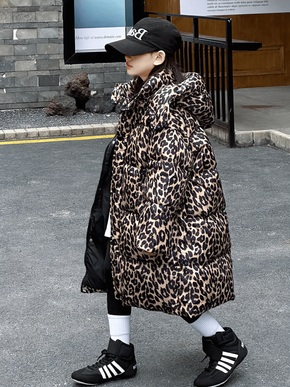 Girl wearing Long Leopard Print Hooded Puffer Coat - SF3527 in outdoor setting, showcasing trendy winter fashion jacket for warmth and style.
