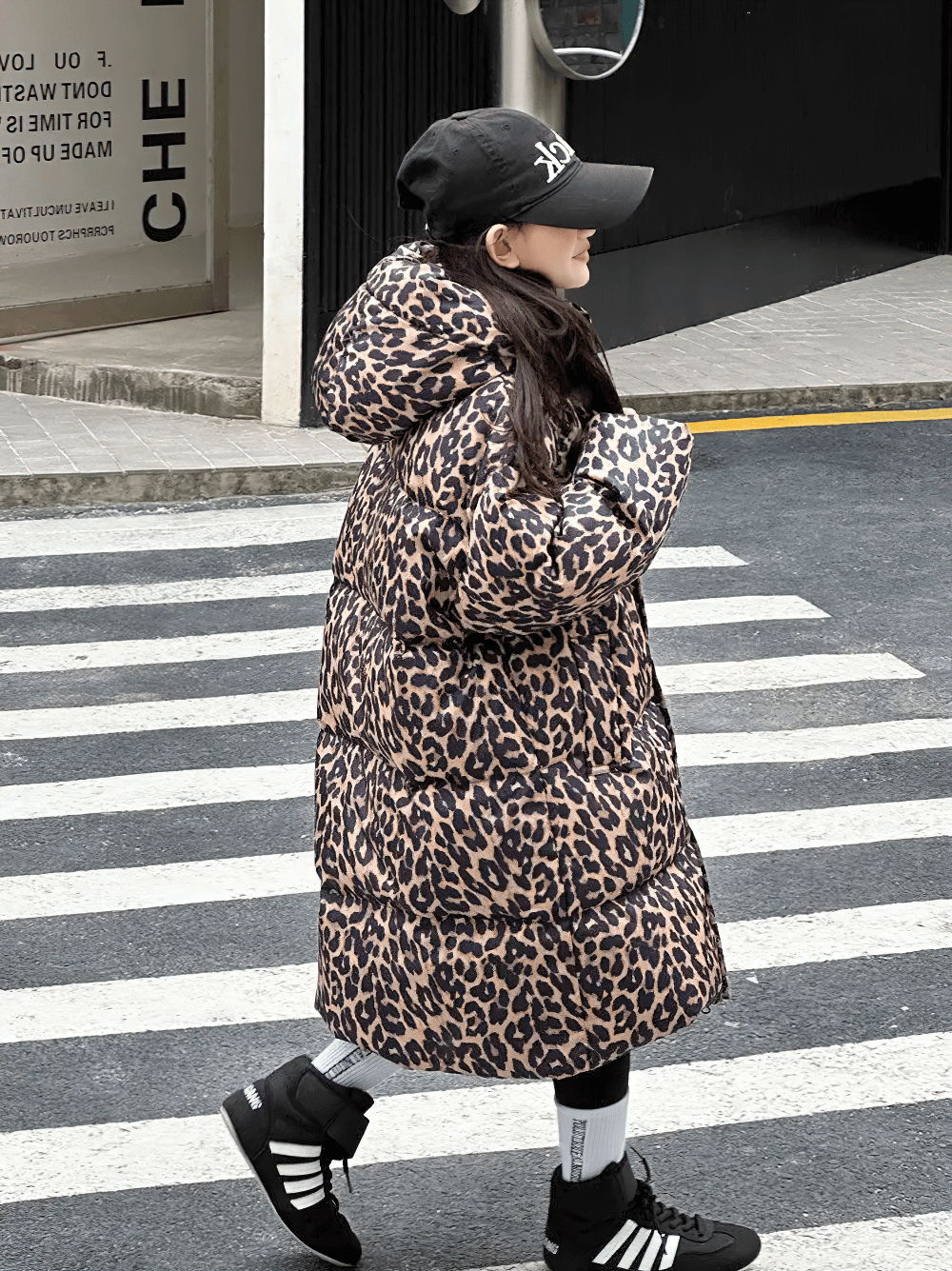 Girl wearing Long Leopard Print Hooded Puffer Coat - SF3527 crossing a street, showcasing stylish and warm animal print winter wear.