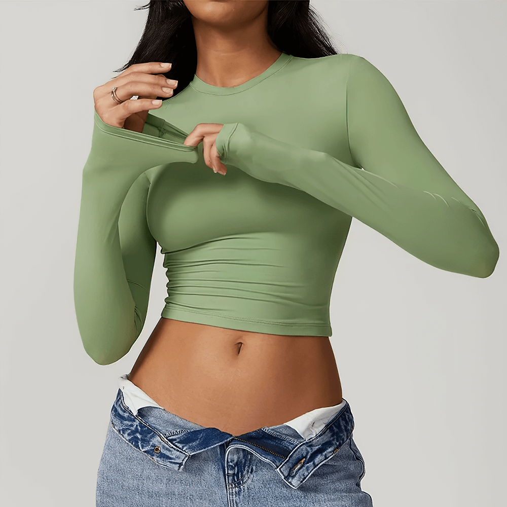 Woman wearing a green long sleeve sports crop top for yoga and fitness, showing the sleek design and comfortable fit of the gym wear.