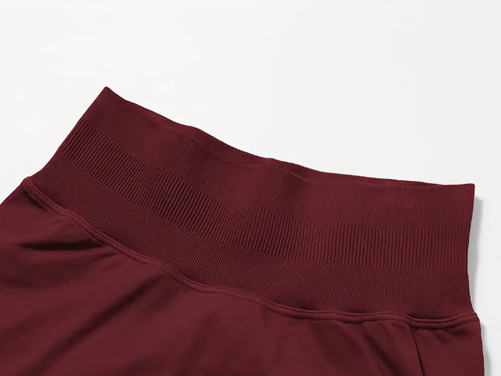 Close-up of maroon high-waisted workout shorts showing ribbed waistband and stretchy fabric for a secure fit and comfort.