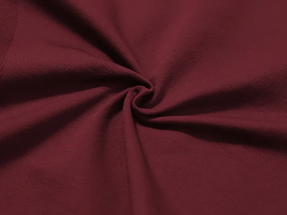 Close-up of soft maroon fabric texture with a twisted detail, perfect for clothing design and cozy fashion.