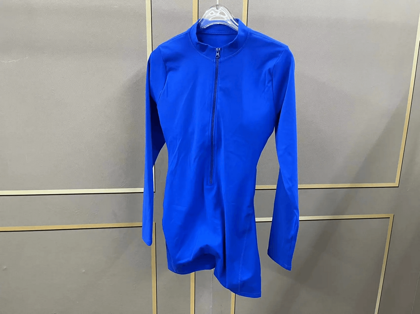 Blue long-sleeved open-back activewear romper with full-zip front, ideal for yoga and gym sessions. Stylish and breathable design.